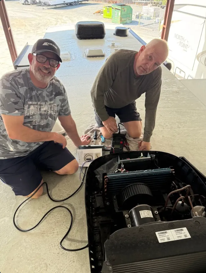 Two technicians working on an RV component